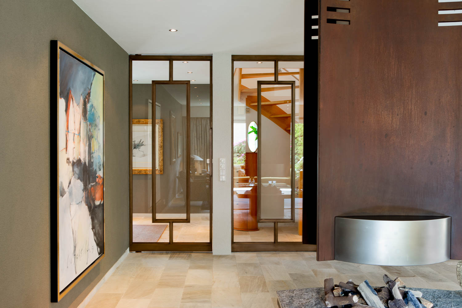 Design bronzen stalen taatsdeur met glas, geïntegreerd in een warm en luxe interieur.